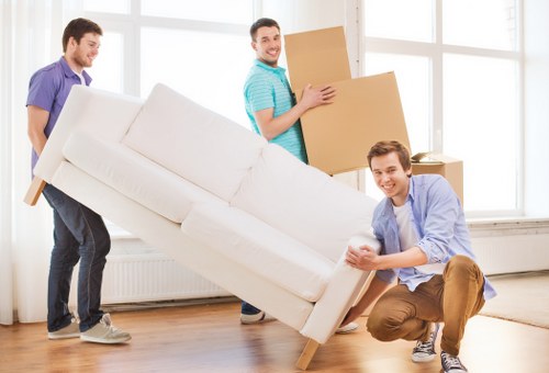 Trained movers handling furniture carefully with equipment